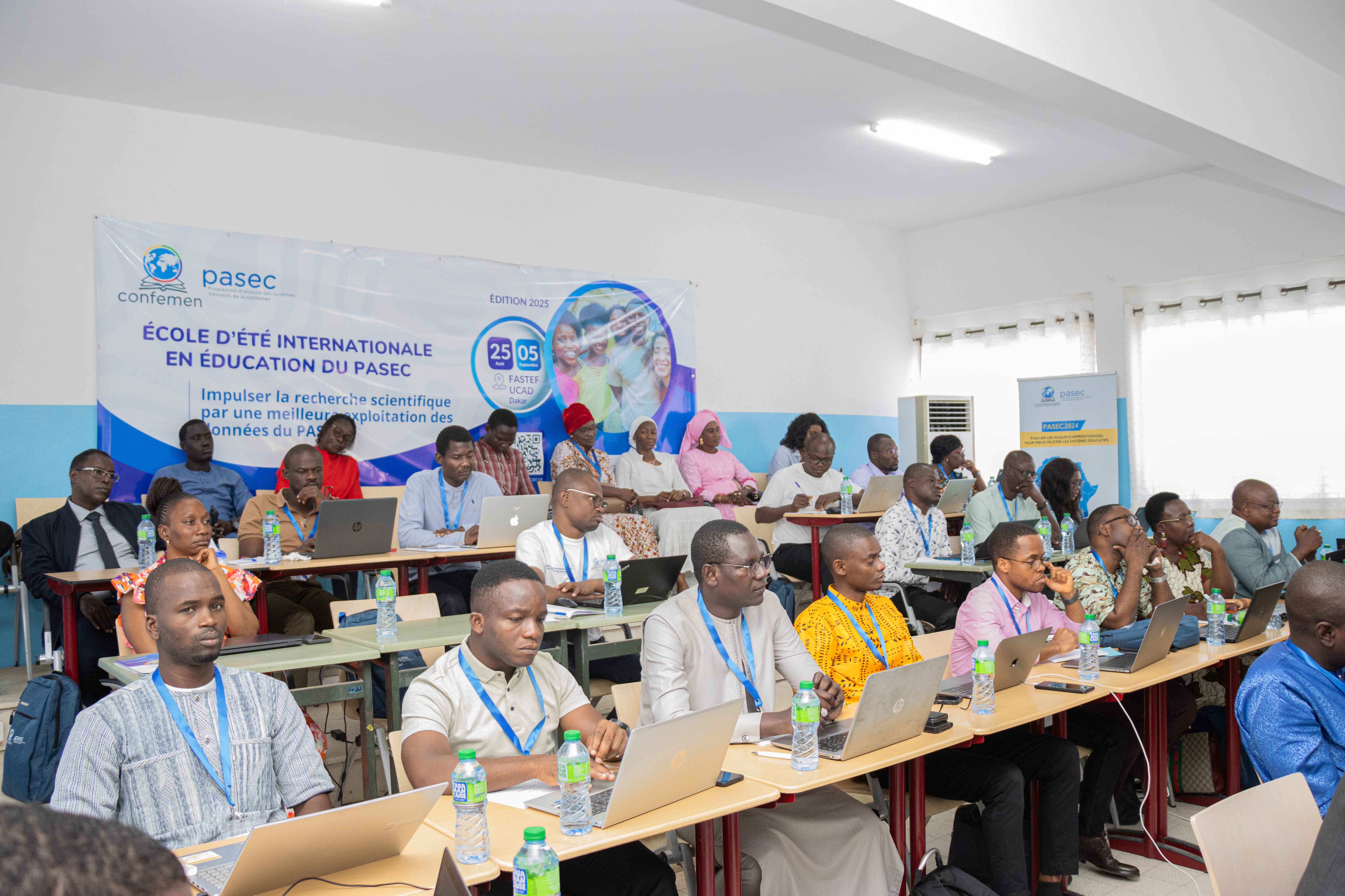 Chercheurs et étudiants lors de l'École d'Été PASEC 2025 - Ambiance académique avec badges d'identification